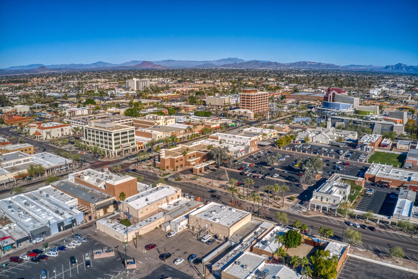 Aerial view of downtown Mesa commercial buildings with mountains in the background.