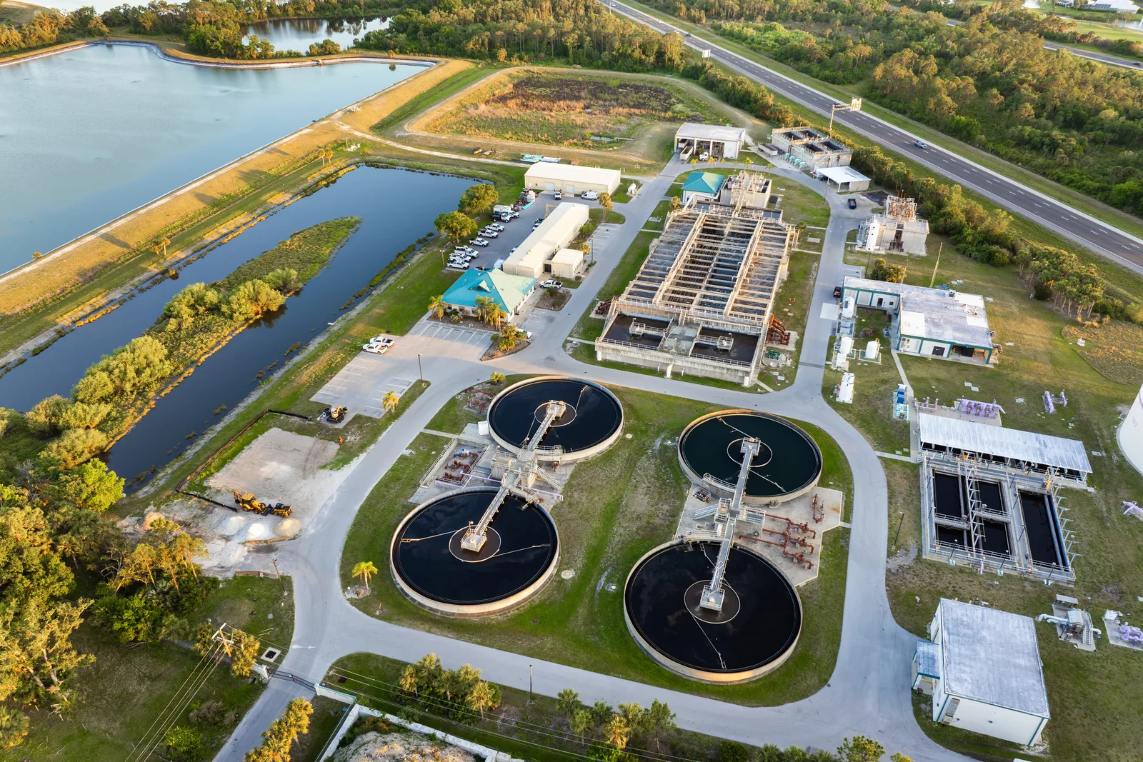 Aerial view of a wastewater treatment plant with circular clarifier tanks and reservoirs.