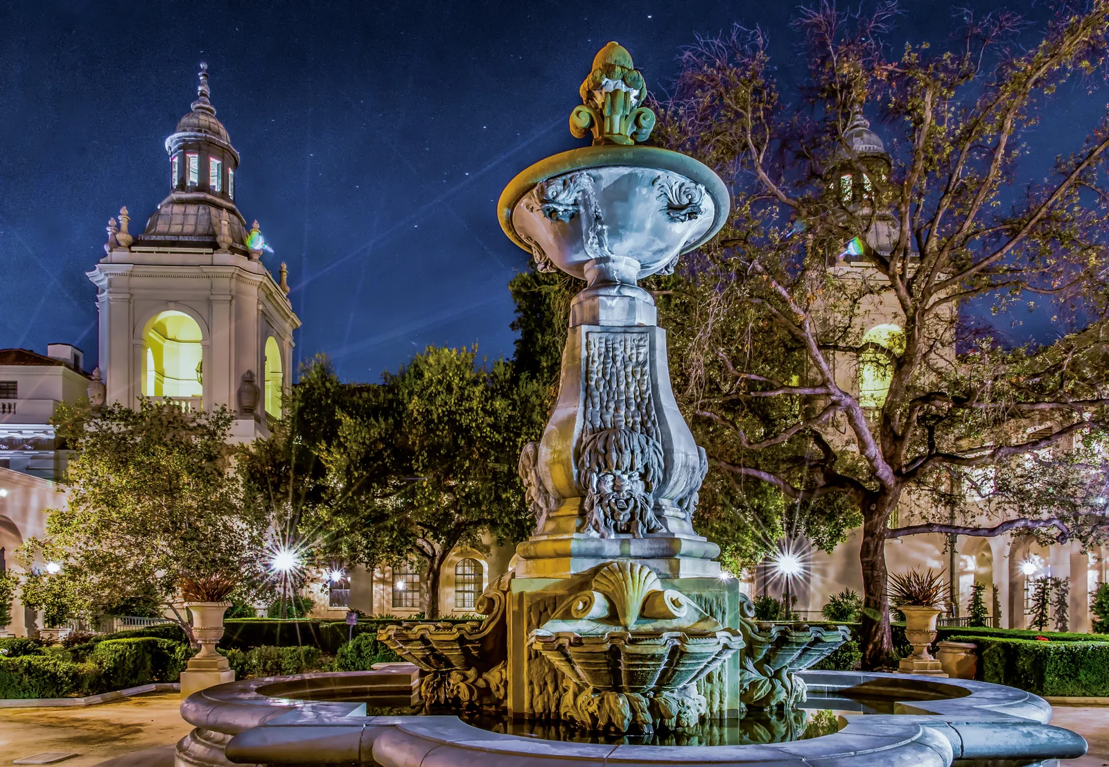 An illuminated stone fountain and historic architecture at night in South Pasadena