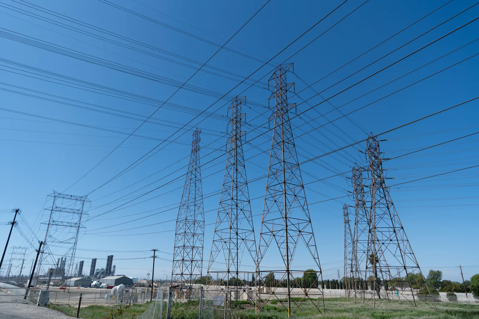 High-voltage transmission towers and power lines near an electrical generating station.