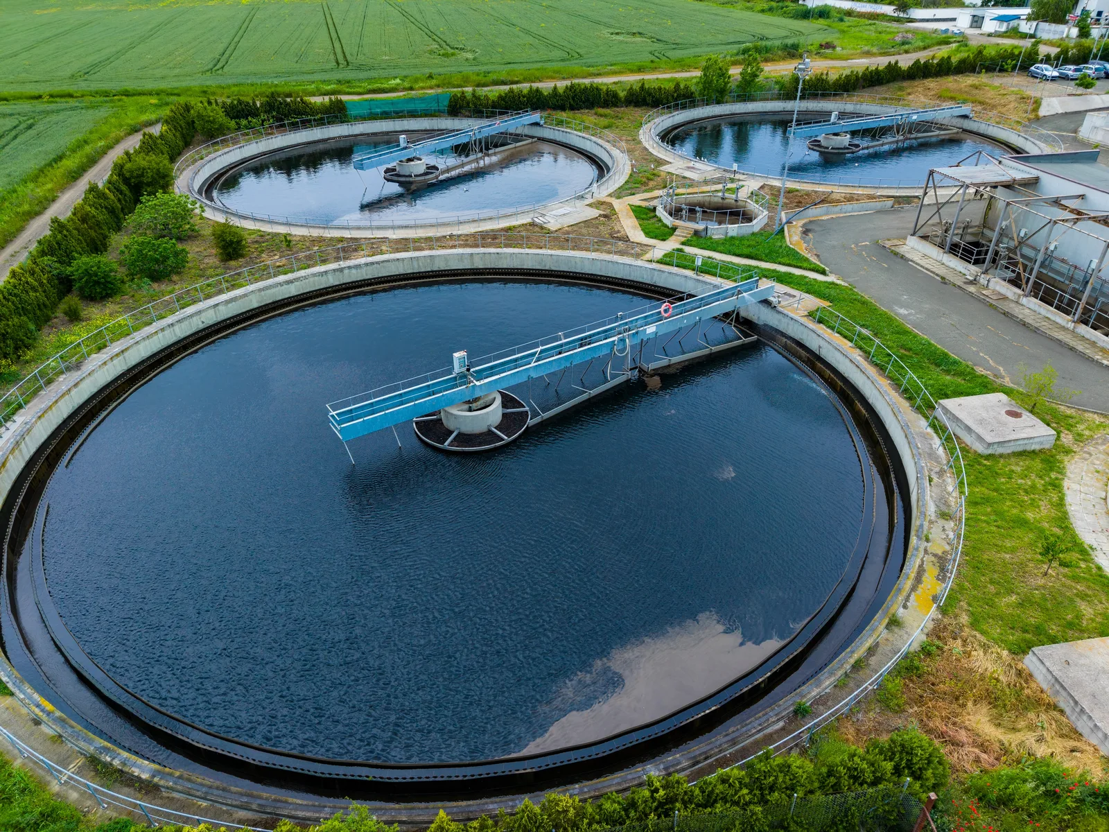 Aerial view of circular clarifier tanks at a wastewater treatment plant.