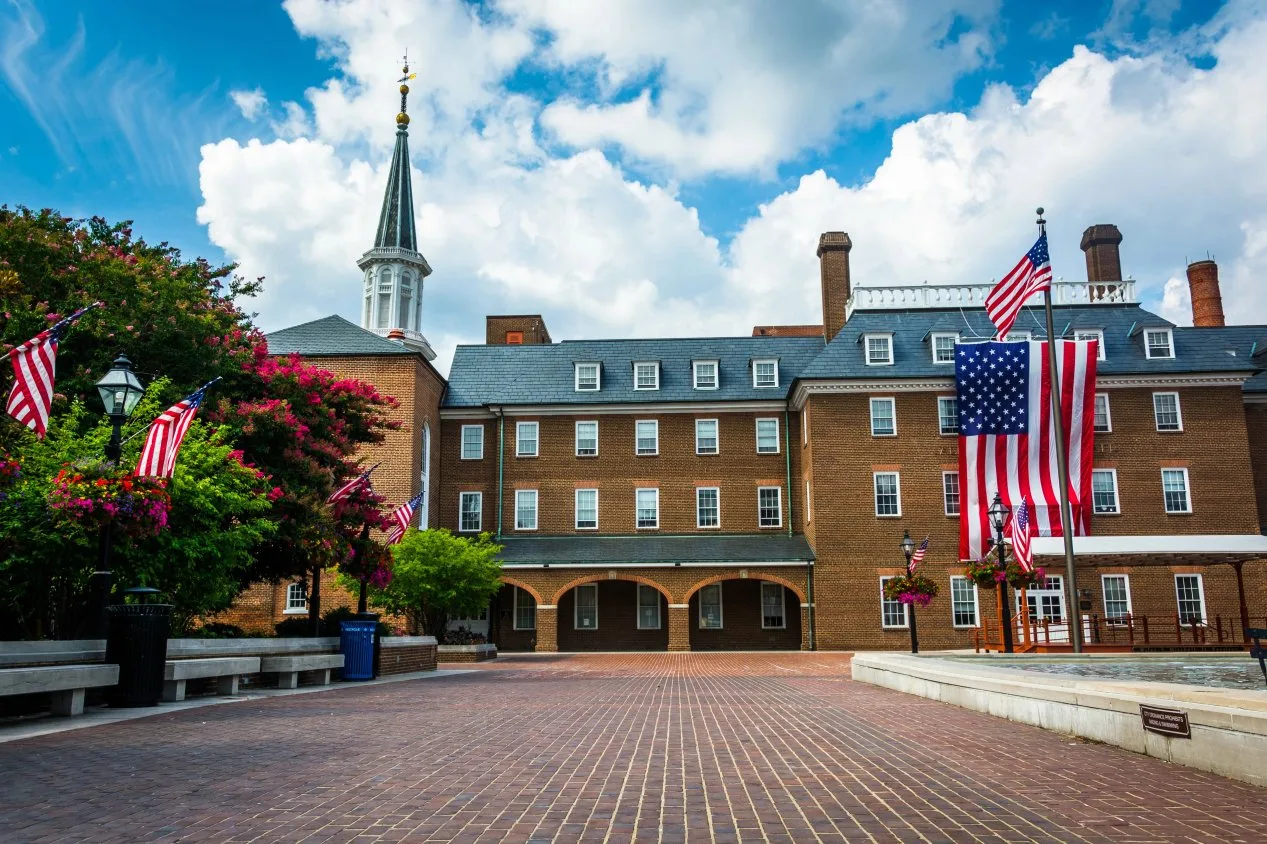 Alexandria City Hall and Market Square featuring historic brick architecture and American flags under a bright blue sky.
